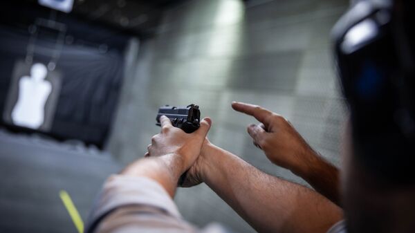 Homem aprende técnica de disparo de arma de fogo. - Sputnik Brasil
