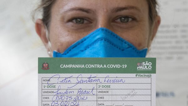 Agente da Saúde mostra seu certificado de vacinação, após receber primeira dose de imunizante contra a COVID-19, em São Paulo, 3 de fevereiro de 2021  - Sputnik Brasil