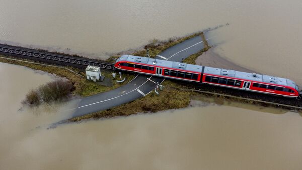 Trem passa cruzamento de ferrovia rodeado por água devido a inundação causada pela chuva e degelo, Alemanha, 3 de fevereiro de 2021 - Sputnik Brasil