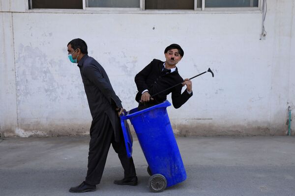 Homem trajado de Charlie Chaplin em lixeira durante show de rua, Peshawar, Paquistão, 28 de janeiro de 2021 - Sputnik Brasil