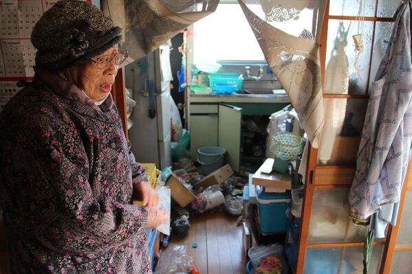 Mulher japonesa mostra utensílios de cozinha espalhados em sua casa na cidade de Soma, prefeitura de Fukushima
 - Sputnik Brasil