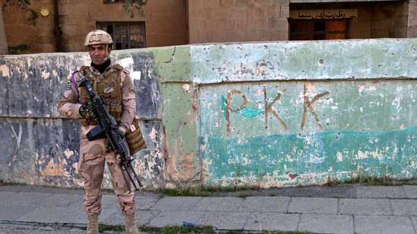 Soldado iraquiano em frente ao muro com inscrição PKK - Sputnik Brasil