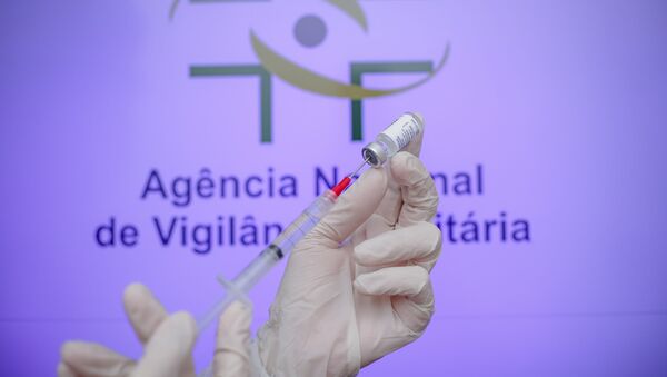 Em São José dos Campos, interior de São Paulo, uma dose da vacina russa Sputnik V é manuseada em frente a um logo da Agência Nacional de Vigilância Sanitária (Anvisa), em 2 de fevereiro de 2021 - Sputnik Brasil