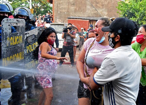 Familiares de detentos na prisão de Tacumbú, Paraguai, são pulverizados com água pela polícia durante confrontos após a morte de seis presos, 16 de fevereiro de 2021 - Sputnik Brasil