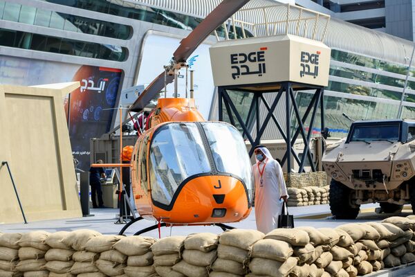 Homem perto de um helicóptero no estande do grupo tecnológico EDGE na exposição de defesa IDEX 2021 em Abu Dhabi, EAU, 22 de fevereiro de 2021. - Sputnik Brasil