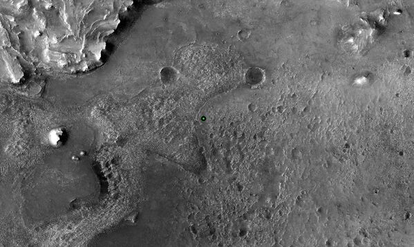 Um ponto verde marca o lugar de pouso do rover Perseverance da NASA na cratera Jezero, imagem feita pela câmera de Experimento de Ciência em Imagem de Alta Resolução (HiRISE, na sigla em inglês), 18 de fevereiro de 2021 - Sputnik Brasil