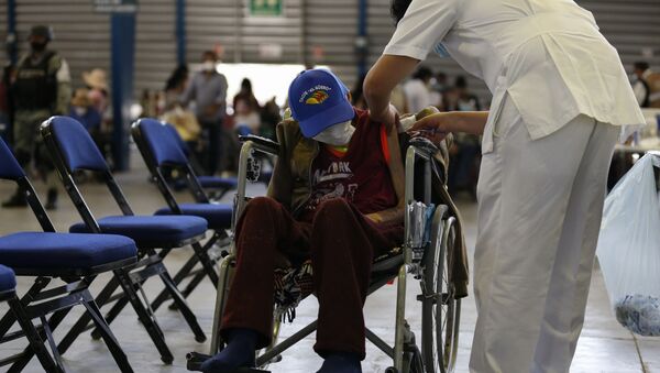 Na Cidade do México, um profissional de saúde aplica uma dose da vacina Sputnik V contra a COVID-19 em um idoso, no Palacio de Los Deportes, em 24 de fevereiro de 2021 - Sputnik Brasil