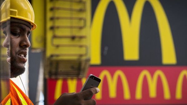 A customer looks at his phone while exiting a McDonald's in Times Square in New York July 23, 2015. - Sputnik Brasil