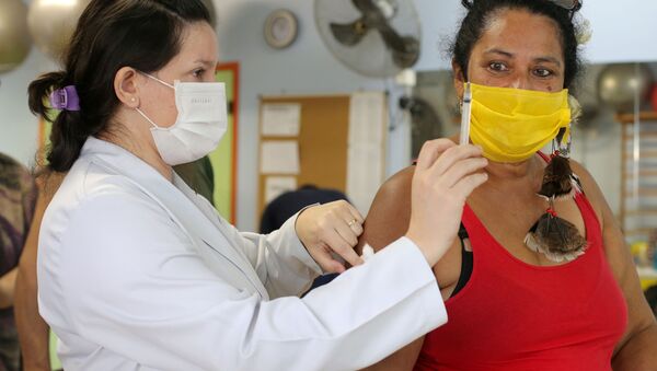 Mulher indígena observa segunda dose da vacina CoronaVac contra o SARS-CoV-2 em uma unidade de saúde de Guarulhos, São Paulo, Brasil, 2 de março de 2021 - Sputnik Brasil