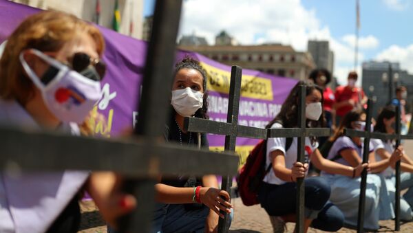 Mulheres seguram cruzes durante protesto contra a resposta do presidente Jair Bolsonaro à pandemia de COVID-19, em São Paulo, 8 de março de 2021 - Sputnik Brasil