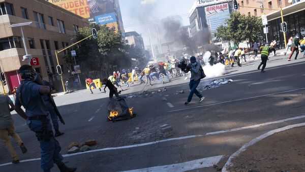 Agentes do Serviço de Polícia da África do Sul (SAPS) usam gás lacrimogêneo para dispersar protesto de estudantes em Braamfontein, Joanesburgo, África do Sul, nesta quarta-feira, 10 de março de 2021 - Sputnik Brasil