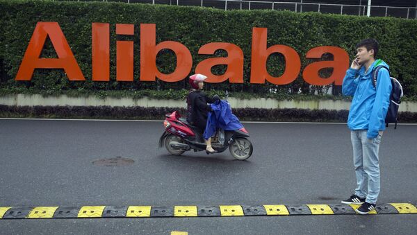 Homem e mulher em frente do logo do Alibaba Group, na sede da empresa em Hangzhou, China, 27 de maio de 2016 - Sputnik Brasil