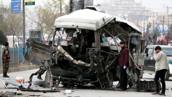Autoridades afegãs inspecionam um micro-ônibus danificado após uma explosão em Cabul, Afeganistão, em 15 de março de 2021 - Sputnik Brasil