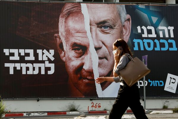 Mulher passa por uma faixa de campanha eleitoral do partido Azul e Branco representando seu líder, o ministro da Defesa Benny Gantz, ao lado do primeiro-ministro israelense Benjamin Netanyahu
 - Sputnik Brasil
