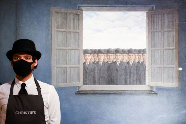 Assistente da galeria posa ao lado de uma obra do artista René Magritte denominada Le Mois des Vendanges durante uma sessão fotográfica
 - Sputnik Brasil
