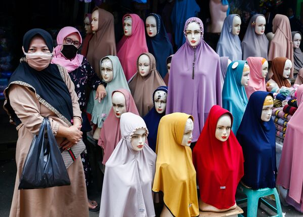 Mulheres usando máscaras protetoras ao lado de manequins com hijab no mercado têxtil de Tanah Abang, Indonésia
 - Sputnik Brasil