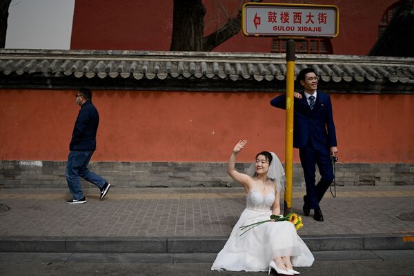 Recém-casados posam durante sessão fotográfica em frente à Torre do Tambor em Pequim, China
 - Sputnik Brasil