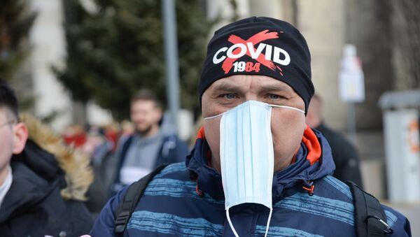 Em Varsóvia, na Polônia, manifestantes protestam contra o lockdown nacional e outras restrições sociais em meio à pandemia da COVID-19, em 20 de março de 2021 - Sputnik Brasil