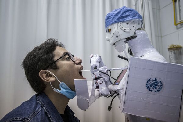 Robô coleta, com um chumaço de algodão, material para fazer análise de COVID-19 em um hospital egípcio
 - Sputnik Brasil