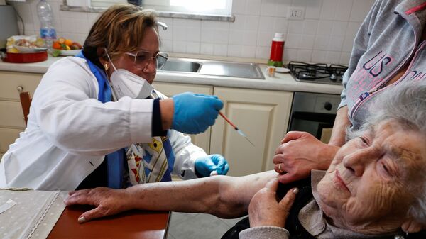 Em Nápoles, na Itália, uma profissional de saúde aplica uma vacina contra a COVID-19 em uma idosa, em 30 de março de 2021 - Sputnik Brasil