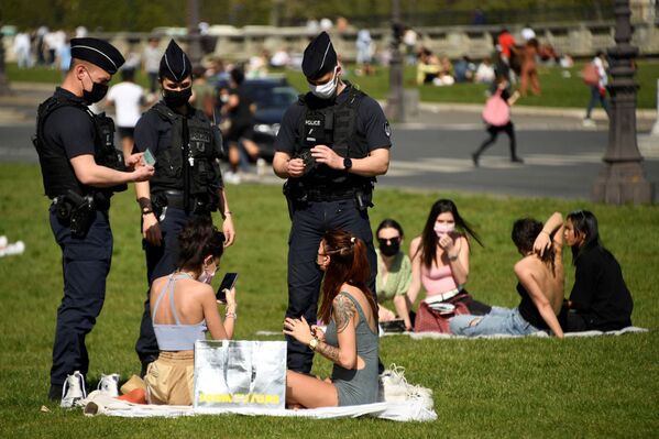 Policiais franceses verificam documentos das pessoas que descansam no gramado em Paris, França, 31 de março de 31 - Sputnik Brasil