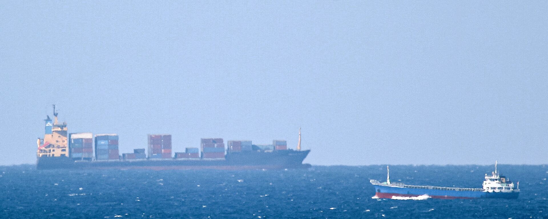 Um navio de carga não identificado navega em direção ao estreito de Ormuz ao largo da costa de Khasab, Omã (foto tirada em 15 de janeiro de 2012). O Irã informou que seu navio Saviz ficou danificado após sofrer uma explosão no mar Vermelho - Sputnik Brasil, 1920, 23.03.2022