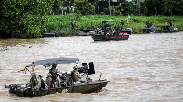 Um barco da marinha colombiana patrulha o rio Arauca enquanto um barco da marinha venezuelana permanece ancorado na fronteira entre a Colômbia e a Venezuela, visto de Arauquita, Colômbia, em 28 de março de 2021 - Sputnik Brasil