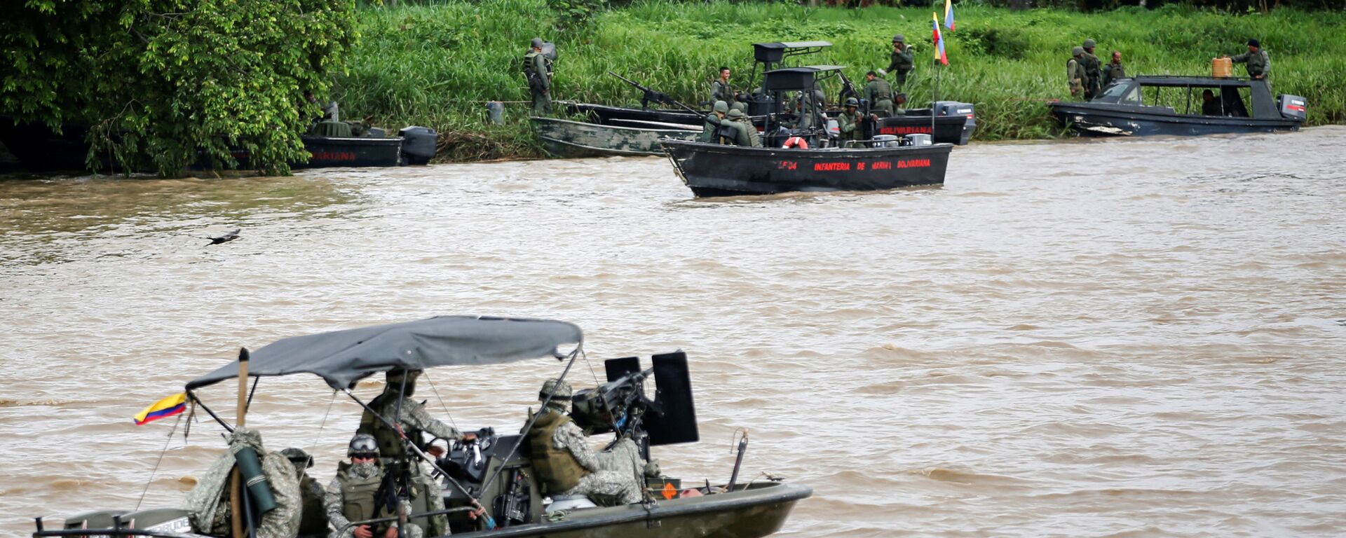 Um barco da marinha colombiana patrulha o rio Arauca enquanto um barco da marinha venezuelana permanece ancorado na fronteira entre a Colômbia e a Venezuela, visto de Arauquita, Colômbia, em 28 de março de 2021 - Sputnik Brasil, 1920, 09.12.2021