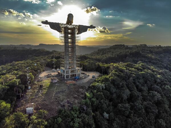 Luz do pôr do sol iluminando a gigante estátua Cristo Protetor - Sputnik Brasil