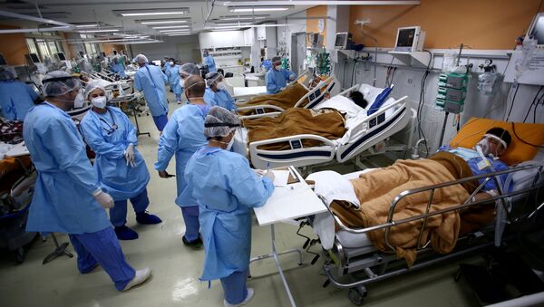 Em Porto Alegre, capital do estado brasileiro do Rio Grande do Sul, profissionais de saúde acompanham pacientes em meio à pandemia da COVID-19, em 11 de março de 2021 - Sputnik Brasil