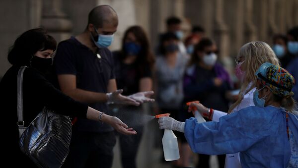 Em Buenos Aires, capital da Argentina, profissionais de saúde higienizam mãos de pessoas em fila para teste de detecção da COVID-19, em 13 de abril de 2021 - Sputnik Brasil