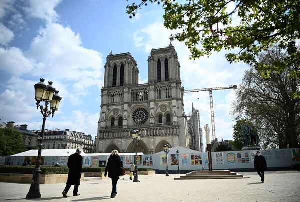 Pessoas caminham em frente da catedral de Norte-Dame, danificada por um incêndio há dois anos, Paris, França, 15 de abril de 2021 - Sputnik Brasil