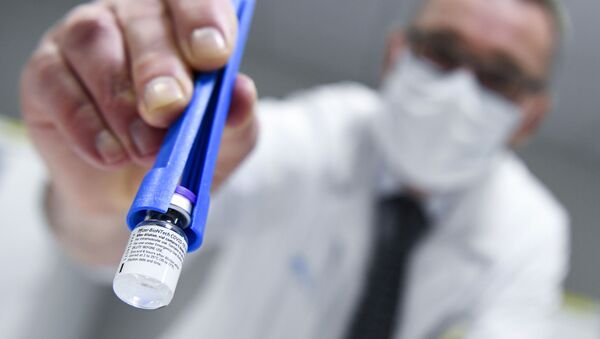 Profissional de saúde segura um frasco da vacina Pfizer-BioNTech COVID-19 enquanto eles são descongelados em um laboratório em Leuven, na Bélgica - Sputnik Brasil