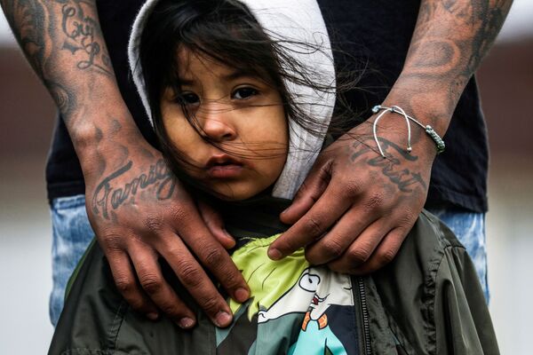 Residente de Brooklyn com sua filha de três anos de idade durante protestos em frente ao Departamento de Polícia de Brooklyn, 13 de abril de 2021 - Sputnik Brasil