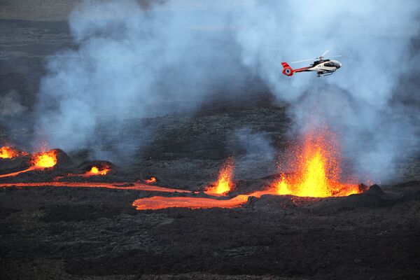 Helicóptero sobrevoa lava que corre do vulcão Piton de la Fournaise, na parte oriental da ilha de Reunião, departamento ultramarino da França, 10 de abril de 2021 - Sputnik Brasil