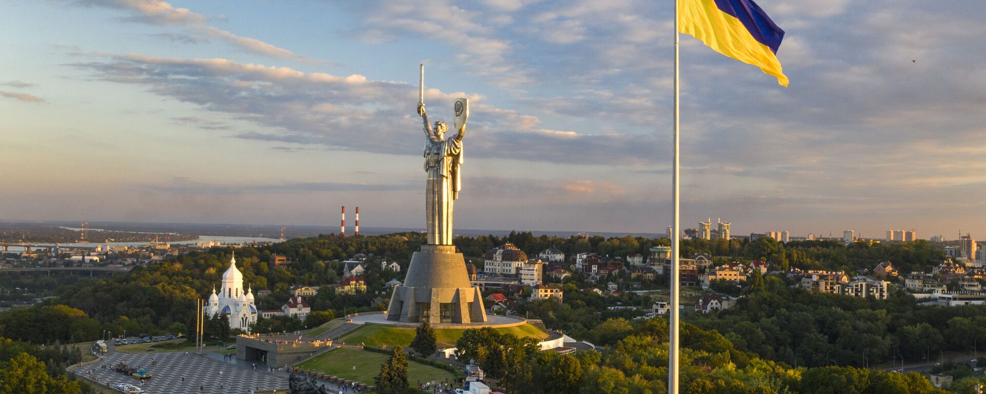 A maior bandeira da Ucrânia está hasteada a cerca de 90 metros acima da cidade, pois foi instalada na véspera do Dia da Bandeira do Estado, com o Monumento à Pátria Mãe no centro, em Kiev, Ucrânia, sábado, 22 de agosto de 2020 - Sputnik Brasil, 1920, 03.09.2024