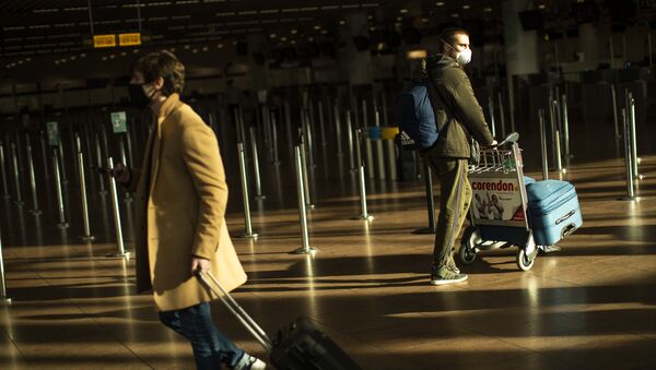 Viajantes, usando máscaras faciais contra COVID-19, caminham no Aeroporto Internacional de Bruxelas, na Bélgica, 22 de janeiro de 2021 - Sputnik Brasil