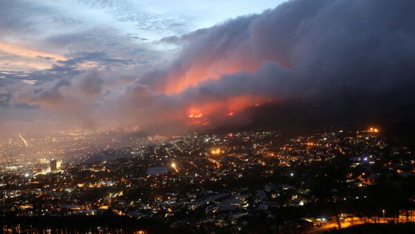 Chamas são vistas perto da cidade, alimentadas por ventos fortes, após um incêndio florestal nas encostas da Table Mountain na Cidade do Cabo, África do Sul, em 19 de abril de 2021 - Sputnik Brasil