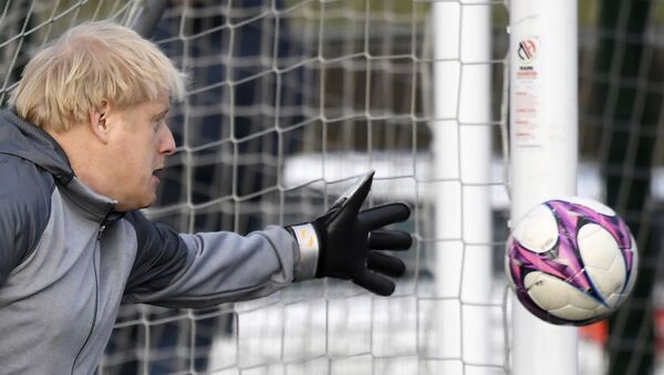Em Cheadle Hulme, na Inglaterra, o primeiro-ministro do Reino Unido, Boris Johnson, brinca como goleiro durante campanha antes de uma partida local entre times infantis femininos, em 7 de dezembro de 2019 - Sputnik Brasil