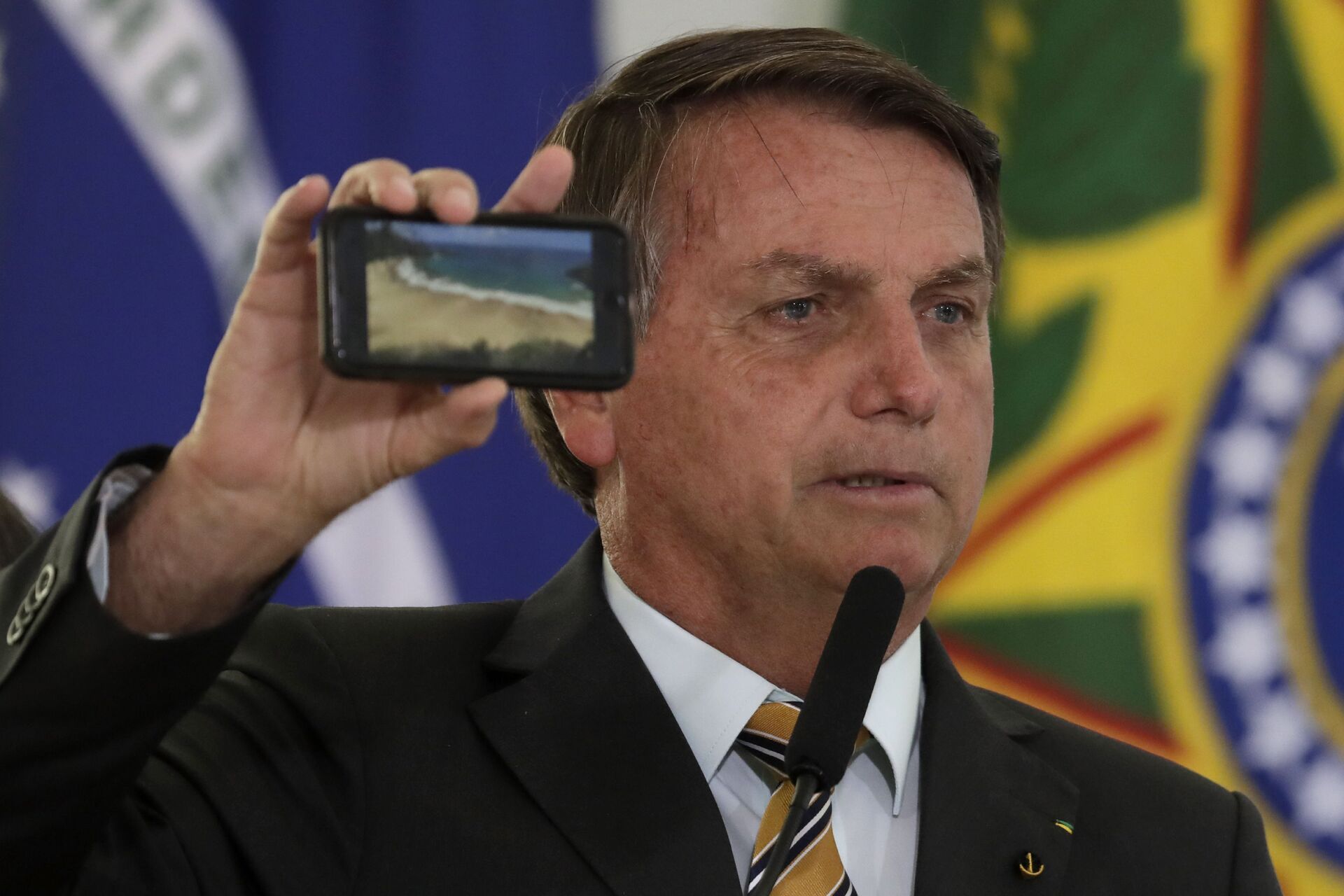 Jair Bolsonaro mostra a foto de uma praia durante cerimônia de apresentação de um programa para reiniciar o turismo, em meio à pandemia de COVID-19, em 11 de novembro de 2020 - Sputnik Brasil, 1920, 09.11.2021