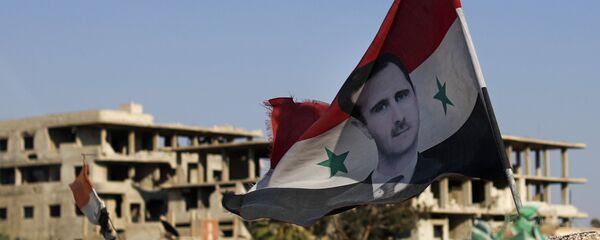Bandeira nacional da Síria com foto de Bashar Assad, presidente do país, voando em um posto de controle do Exército sírio, na cidade de Douma, perto de Damasco, Síria, 15 de julho de 2018 - Sputnik Brasil
