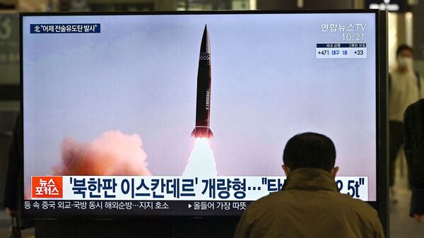 Um homem assiste a uma tela de televisão na estação ferroviária de Suseo, em Seul, em 26 de março de 2021, exibindo imagens de notícias do mais recente teste de projétil tático guiado da Coreia do Norte - Sputnik Brasil