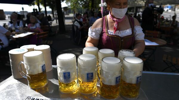 Em Munique, na Alemanha, uma garçonete carrega canecas de cerveja na região onde a Oktoberfest seria realizada se não tivesse sido cancelada devido à pandemia, em 3 de maio de 2021 - Sputnik Brasil