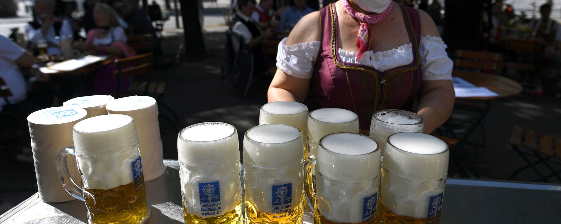 Em Munique, na Alemanha, uma garçonete carrega canecas de cerveja na região onde a Oktoberfest seria realizada se não tivesse sido cancelada devido à pandemia, 3 de maio de 2021. - Sputnik Brasil, 1920, 06.04.2022