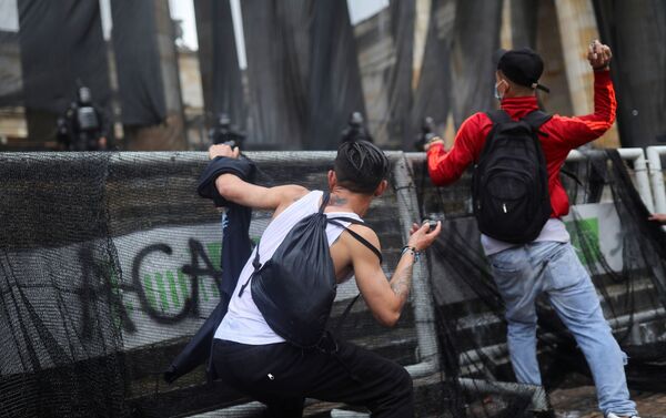 Manifestantes jogam pedras durante os protestos em Bogotá, Colômbia, 5 de maio de 2021 - Sputnik Brasil