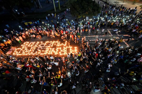 Pessoas se reúnem ao redor de velas e de inscrição na rua por nossos mortos durante vigília em Cali, Colômbia, 5 de maio de 2021 - Sputnik Brasil