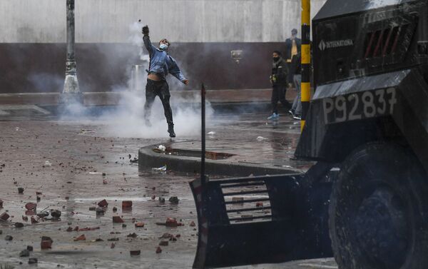 Manifestante joga pedra a um carro policial durante protestos antigovernamentais na praça Bolívar, Bogotá, Colômbia, 5 de maio de 2021 - Sputnik Brasil