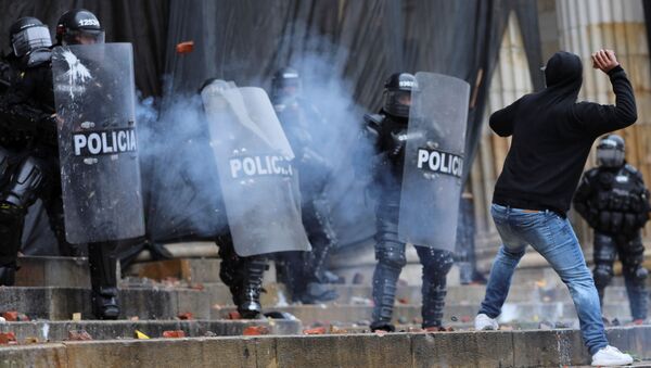 Manifestante entre em confronto com policiais durante protestos em Bogotá, na Colômbia - Sputnik Brasil