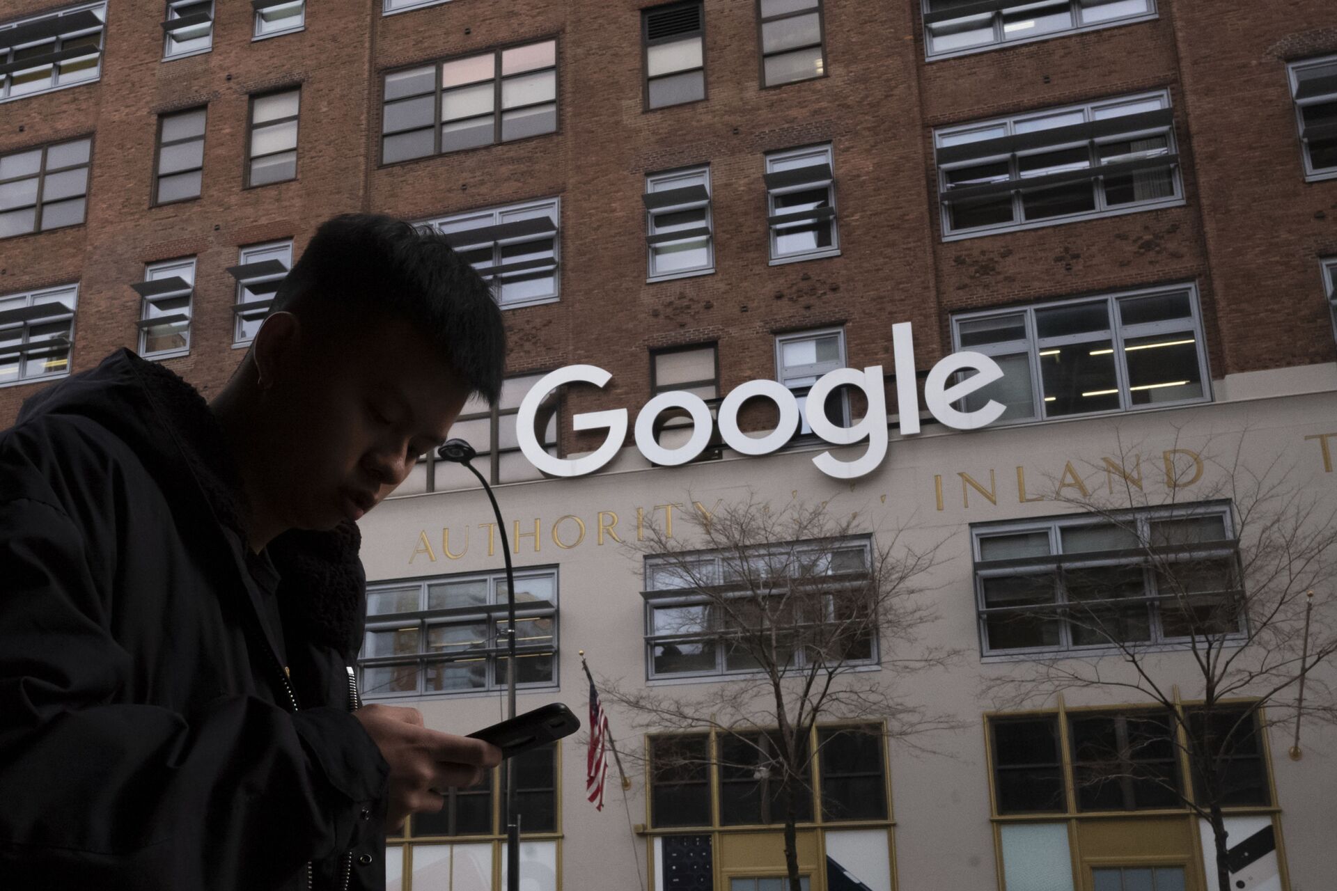 Homem usando um telefone celular passando pelos escritórios do Google em Nova York, 17 de dezembro de 2018 - Sputnik Brasil, 1920, 10.02.2022
