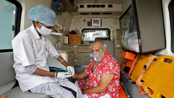 Paramédico usa oxímetro para medir o nível de oxigênio de paciente dentro da ambulância enquanto espera ser internado no hospital em Ahmedabad, Índia, 22 de abril de 2021 - Sputnik Brasil
